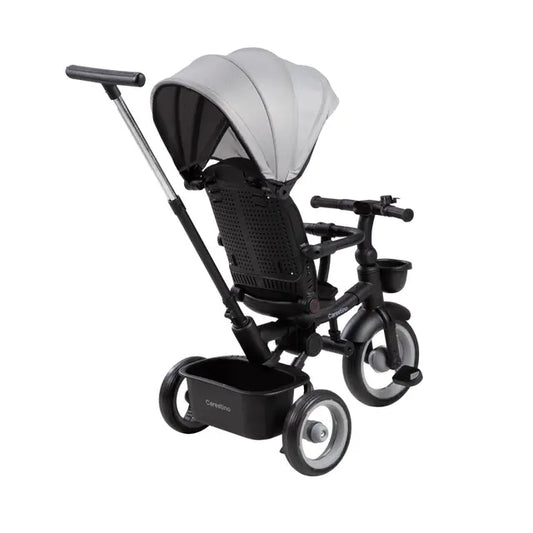 Triciclo infantil gris con capota y canasto delantero, ruedas con doble soporte frontal.